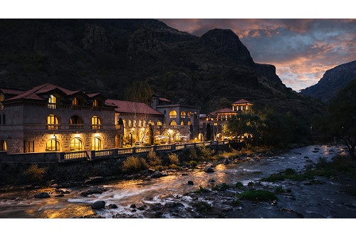 A nighttime view of a castle-like building with dramatic lighting, which sits beside a rushing river and in front of a backdrop of mountains. This is the secret to a great tourism photo.